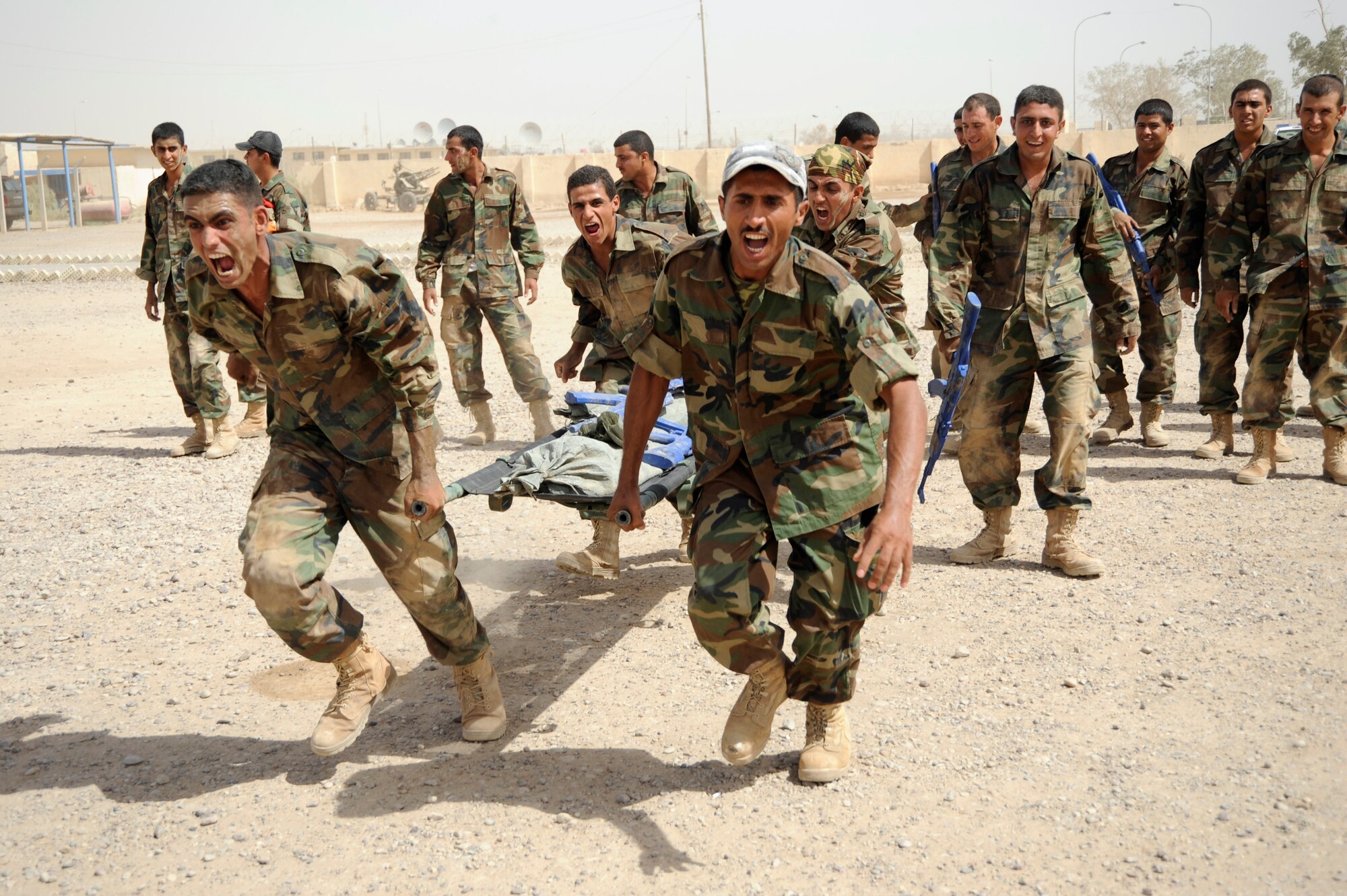 Iraqi air force warrant officers carry a litter weighted down with blue training rifles and sand bags during their run of the tactical course at Al Taji Air Base, Iraq on Sept. 27, 2008. The tactical course tests their ability to work as a team and negotiate a variety of obstacles. (U.S. Air Force photo/Staff Sgt. Paul Villanueva II)