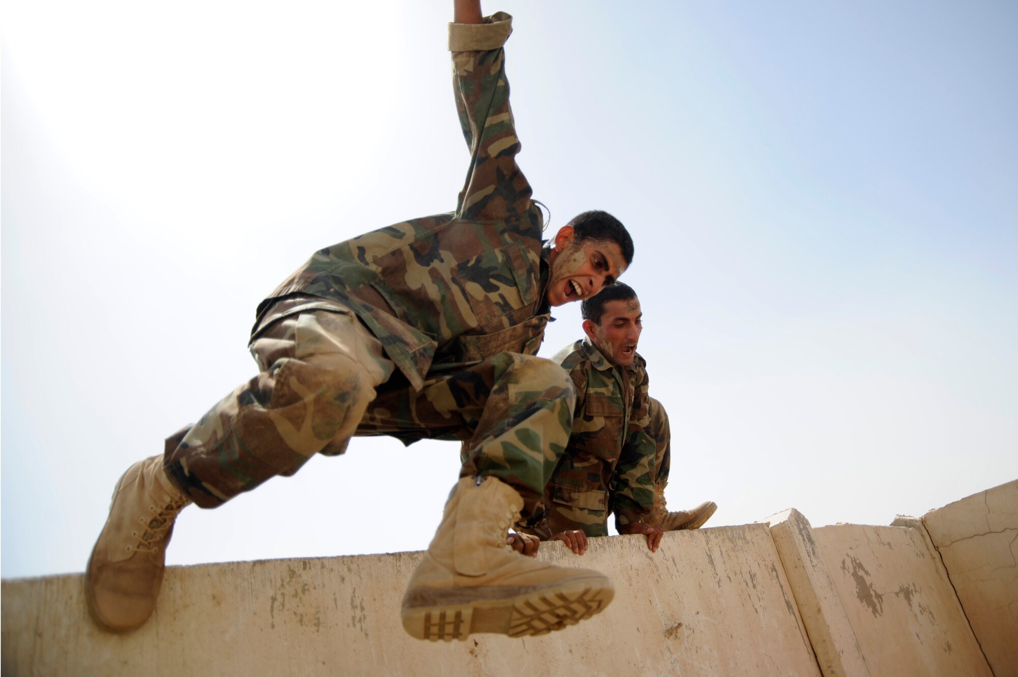AL TAJI AIR BASE, Iraq -- Iraqi air force warrant officers jumps over the high wall portion of the basic military training tactical course. (U.S. Air Force photo/Staff Sgt. Paul Villanueva II)