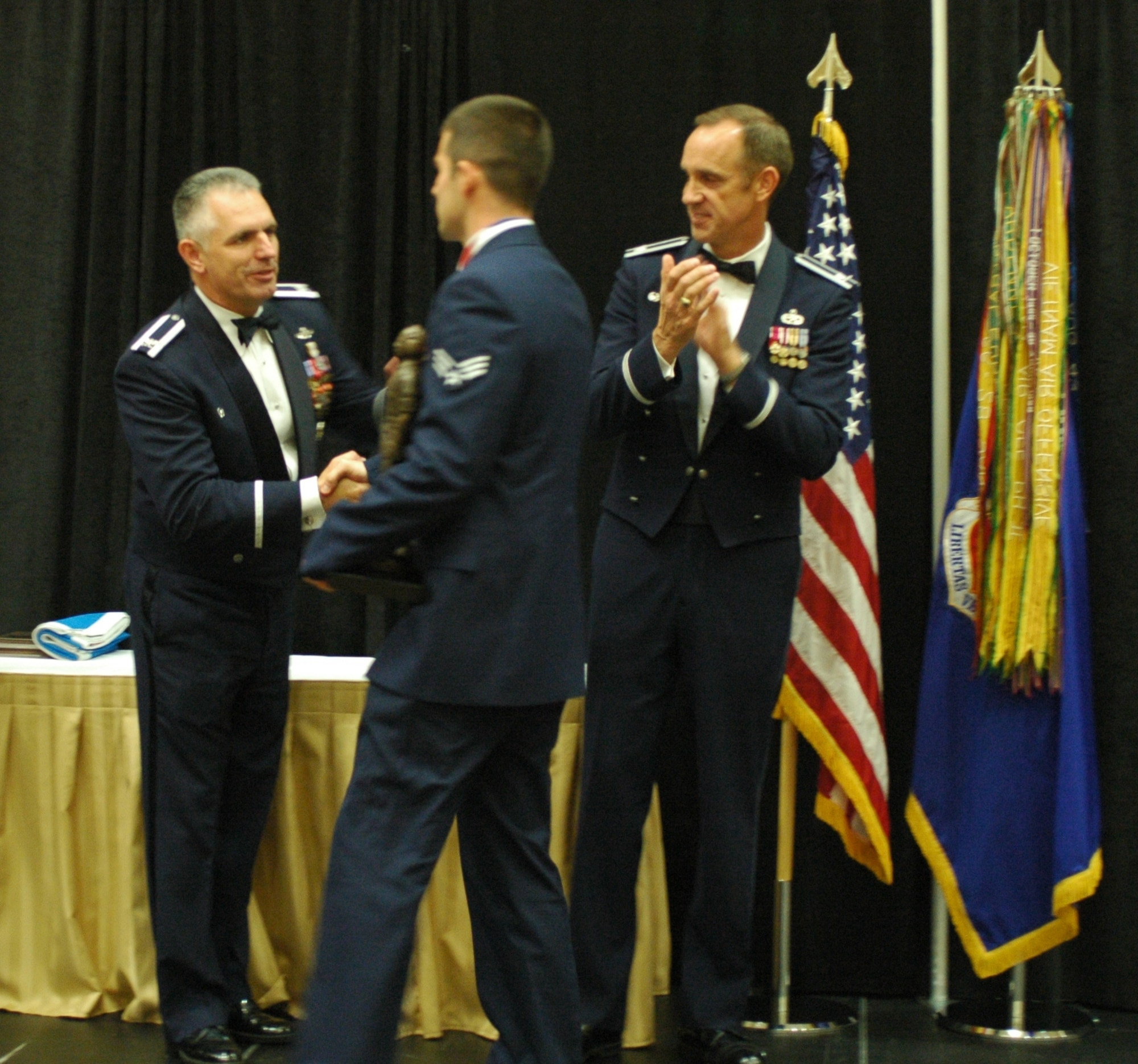 Senior Airman Christopher Collins of the 388th Aircraft Maintenance Squadron (center) is recognized as the Outstanding Aircraft Maintenance Technician of the Year at the MPOY banquet Oct. 4. Brig. Gen. (Select) John Cooper (right), 309th Maintenance Wing commander, and Col. Scott Dennis (left), 388th Fighter Wing commander congratulate the award winner. (Photo by Master Sgt. Ted Robinson)  