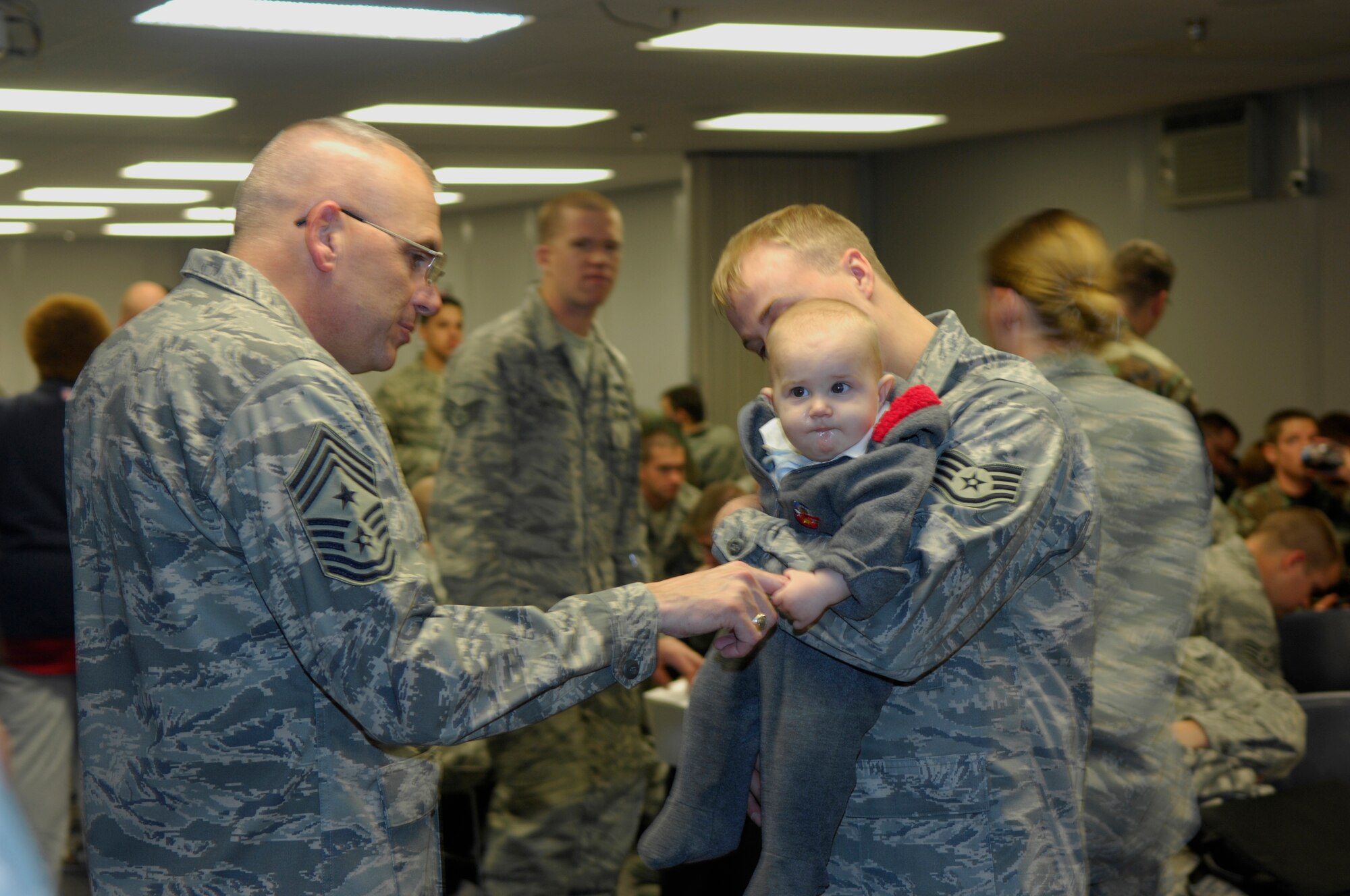 MINOT AIR FORCE BASE, N.D. – Chief Master Sgt. Mark Clark, 5th Bomb Wing command chief, says hello to Staff Sgt. Steven Bailey’s son during the pre-deployment activities here Oct. 2. Sergeant Bailey, a small engine mechanic from the 5th Maintenance Operations Squadron, is one of nearly 300 Airmen from the base deploying to Andersen AFB, Guam to provide U.S. Pacific Command with a continuous bomber presence in the Asia-Pacific region. (U.S. Air Force photo by Senior Airman Joe Rivera)