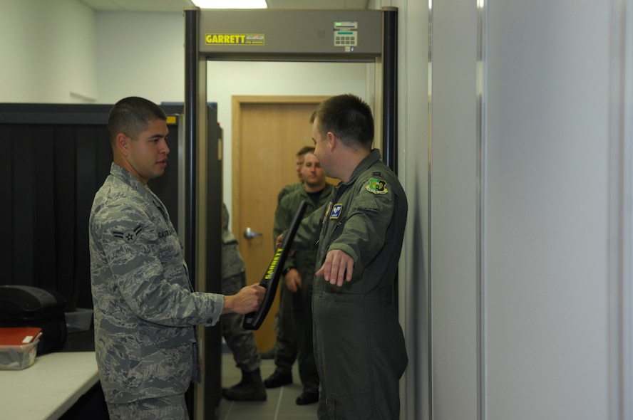 MINOT AIR FORCE BASE, N.D. -- Airman 1st Class Jorge Castro-Lemus, 5th Logistics Readiness Squadron traffic management apprentice, scans 1st Lt. Christopher Daniels, 23rd Bomb Squadron co-pilot, for any unauthorized metals he may have on his person as part of a pre-deployment activity here Oct. 2.  During the four-month deployment, almost 300 Airmen and more than five B-52H Stratofortresses will provide U.S. Pacific Command with a continuous bomber presence in the Asia-Pacific region. (U.S. Air Force photo by Senior Airman Joe Rivera)