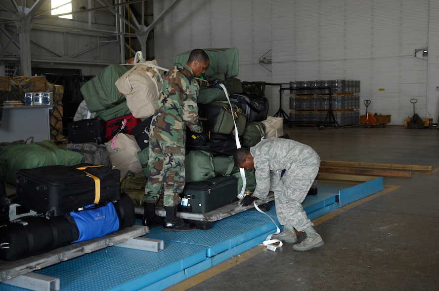 MINOT AIR FORCE BASE, N.D. -- Senior Airman Henry Reed and Airman 1st Class Standley Hawkins,  both of the 5th Logistics Readiness Squadron, secure a pallet load here as part of a deployment to Andersen AFB, Guam, here Oct. 2.  During the four-month deployment, almost 300 Airmen and more than five B-52H Stratofortresses will provide U.S. Pacific Command with a continuous bomber presence in the Asia-Pacific region. (U.S. Air Force photo by Senior Airman Joe Rivera)