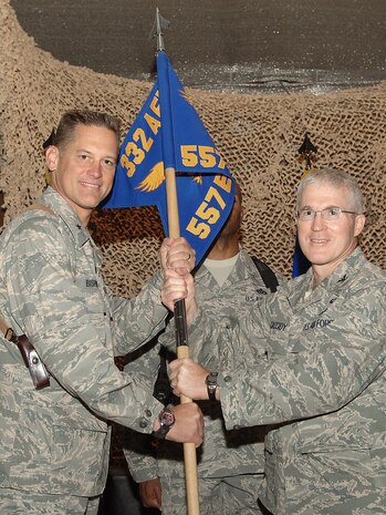 Col. Wilfred Cassidy accepts the guidon and command of the 557th Expeditionary RED HORSE Squadron to during a change-of-command ceremony Oct. 6 at Joint Base Balad, Iraq. Brig. Gen. Brian Bishop (left), the 332nd Air Expeditionary Wing commander, presided over the ceremony.  Cassidy will lead Airmen deployed from the 820th RED HORSE Squadron at Nellis Air Force Base, Nev. They account for more than 70 percent of all RED HORSE Airmen in U.S. Central Command's area of responsibility and will contribute to the unit's mission at 13 locations across the AOR for approximately six months. Cassidy is a native of Fort Fairfield, Maine. (U.S. Air Force photo/Tech. Sgt. Richard Lisum)