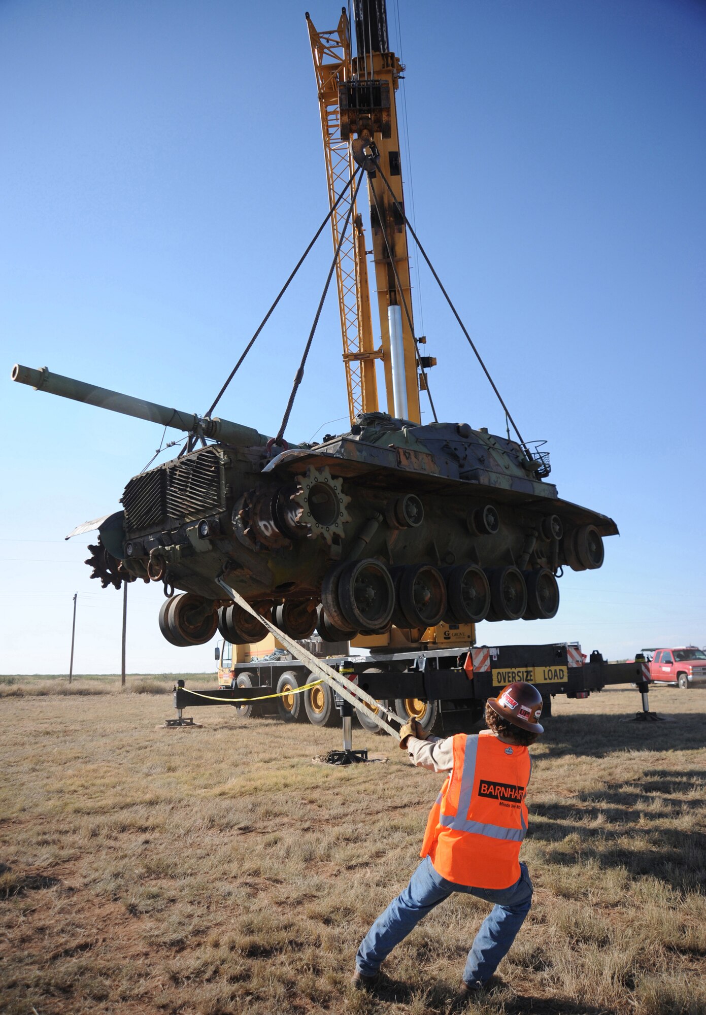 CANNON AIR FORCE BASE, N.M.-- Nick Homyk, from the Barnhart Crane Company, guides an M60 tank for safe positioning on Melrose Air Force Range Oct. 1. The tank is one of nearly 100 that will ultimately arrive to be used as targets for AC-130H Spectre gunships and other aircraft.  (U.S. Air Force photo by Airman Maynelinne De La Cruz)