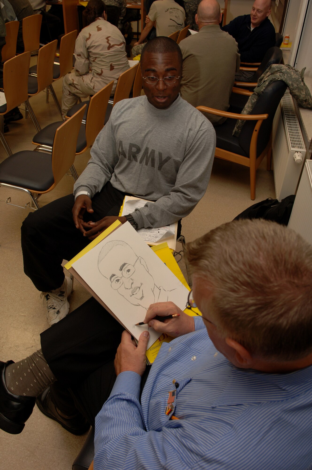 Bruce Higdon, Army cartoonist and artist of the Punderstatements, sketches a characture  of U.S. Army Sgt. Keiron Vaughn, Bravo 201 Brigade Support Battalion, 3rd Brigade, Fort Hood, Texas, at the CASF USO, Ramstein Air Base, Germany, Oct. 2, 2008. Sgt. Vaughn was injured while deployed to Afghanistan. (U.S. Air Force photo by Airman 1st Class Tony R. Ritter) (Released)