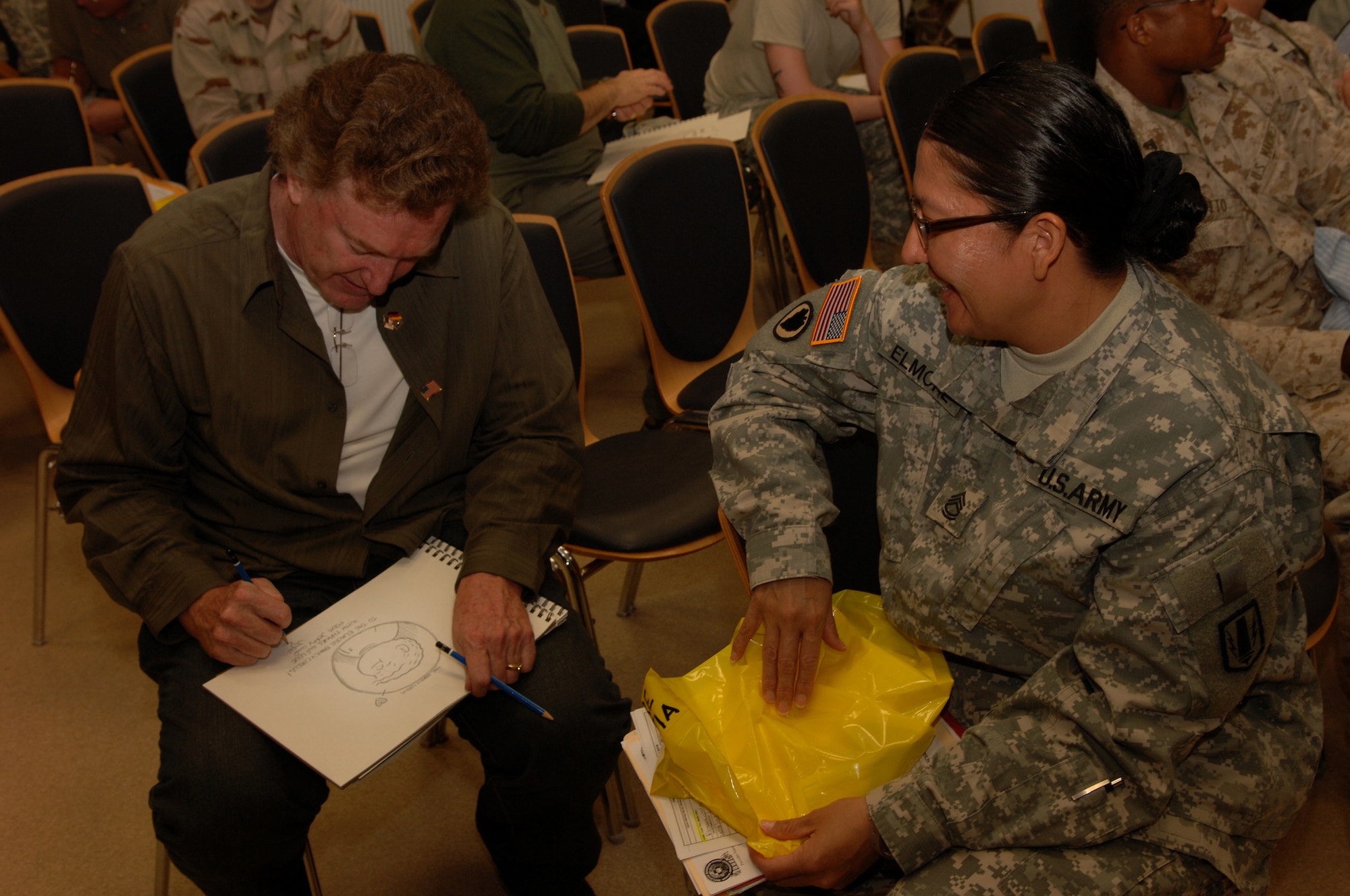 Jeff Keane, National Cartoonist Society president and artist of Family Circus comic strip, sketches a personalized cartoon for U.S. Army Sgt. 1st Class Valesita Elmore, Headquarters and Headquarters Battery 41st Fires Brigade, Ft. Hood, Texas, at the Contingency Aeromedical Staging Facility, Ramstein Air Base, Germany, Oct. 2, 2008. Sgt. Elmore was injured while deployed in Iraq. (U.S. Air Force photo by Airman 1st Class Tony R. Ritter) (Released)