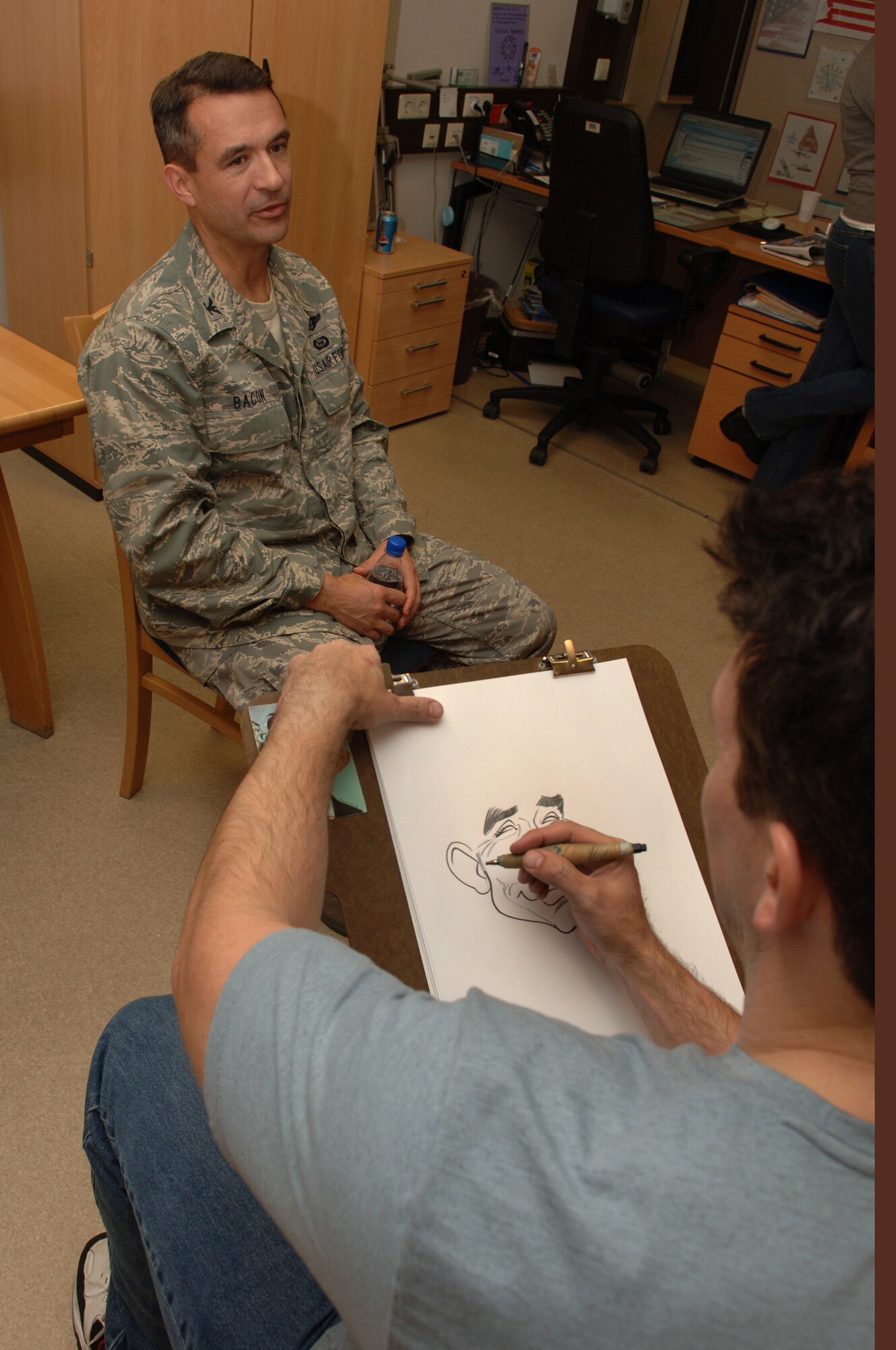 Tom Richmond, MAD Magazine artist, sketches a characture portrait of U.S. Air Force Col. Don Bacon, 435th Air Base Wing commander, at the CASF USO, Ramstein Air Base, Germany, Oct. 2, 2008. Mr. Richmond was one of eight professional cartoonist from the National Cartoonist Society that visited the CASF as part of a morale tour in cooperation with the USO. (U.S. Air Force photo by Airman 1st Class Tony R. Ritter) (Released)