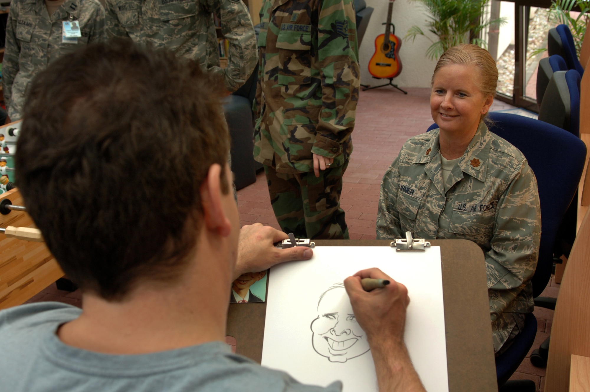 Tom Richmond, MAD Magazine artist, sketches a characture portrait of United States Air Force Maj. Laurie Turner, Contingency Aeromedical Staging Facility Medical Service Corps Officer, at the CASF USO, Ramstein Air Base, Germany, Oct. 2, 2008. Mr. Richmond was one of eight professional cartoonist from the National Cartoonist Society that visited the CASF as part of a morale tour in cooperation with the USO. (U.S. Air Force photo by Airman 1st Class Tony R. Ritter) (Released)