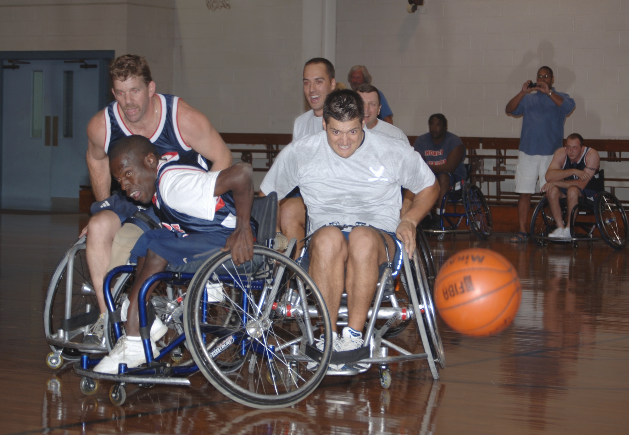 Maj. Lance Rosa-Miranda, 1st Special Operations Wing executive officer, chases a loose ball at the annual wheelchair basketball game Oct. 2 at the Fort Walton Beach Community Center. The competition, pittting Airmen from Hurlburt Field against the Mobile Patriots, a professional wheelchair basketball team, is held in recognition of National Disability Awareness Month. Despite spotting the Commandos 40 points, the Patriots won the game 58-46. (U.S. Air Force photo/ Senior Airman Emily Moore) 
