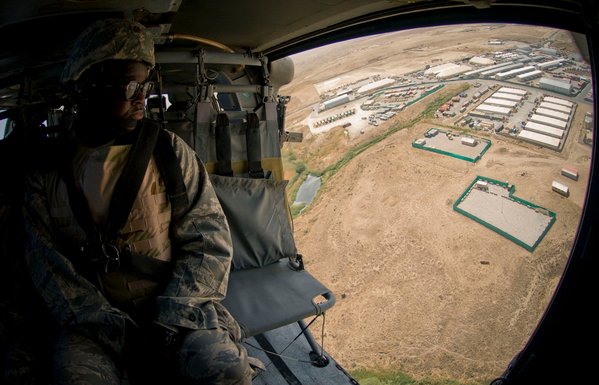 BAGRAM AIR FIELD, Afghanistan -- Ch. Carlton Bivens looks out the door of a UH-60 Black Hawk flying over Lahgman Province, Afghanistan, Sept. 7, 2008. Chaplain Bivens is assigned to the 755 Air Expeditionary Group and regularly makes trips to visit and minister to the Airmen assigned throughout Afghanistan. (U.S. Air Force photo by Staff Sgt. Samuel Morse/Released)