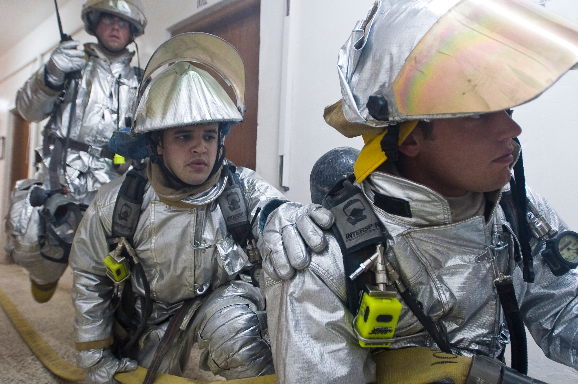 ALI BASE, Iraq --  (Left to right) Tech. Sgt. Garrick Hasty, Airman 1st Class Gregory Ramirez and Senior Airman Nathan Sole, 407th Expeditionary Civil Engineer Squadron fire fighters, prepare to enter a smoke-filled room Oct. 3, 2008. The 407th ECES fire fighters held a structural drill at the passenger terminal here evaluating  from dispatch to the actual response itself. Hasty is deployed from Vandenburg Air Force Base, Calif. Ramirez is deployed from Columbus AFB, Miss. Sole is deployed from 133rd Airlift Wing, Minnesota Air National Gaurd. (U.S. Air Force photo/Airman 1st Class Christopher Griffin)