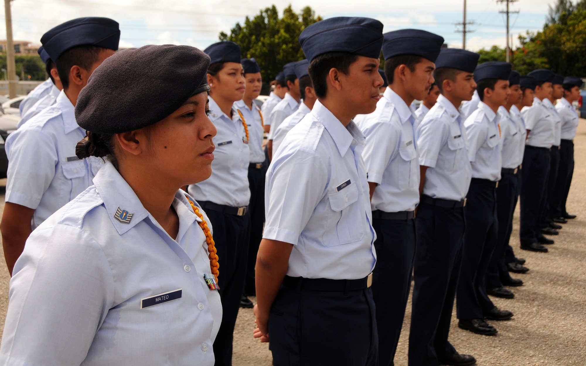 ANDERSEN AIR FORCE BASE, Guam - Cadet Staff Sgt. Pauline Mateo and approximately 50 other cadets of the John F. Kennedy High School Junior Reserve Officer Training Corps stand at ease to while honoring a beloved teacher and mentor, Col. Walter "Tony" Merritt, during his memorial service at the JFK High School in Tammuning, Guam, Oct. 4. Colonel Merritt served as a JROTC instructor for 28 years at JFK. (U.S. Air Force photo by Airman 1st Class Courtney Witt)