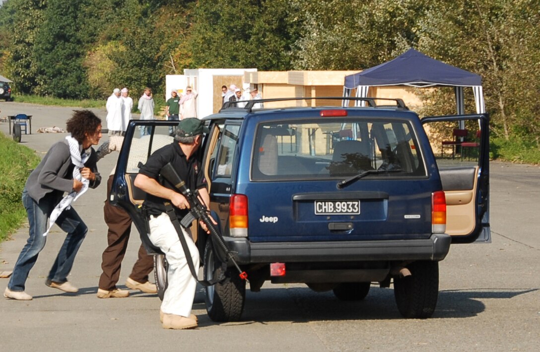 Soldiers, civilians and allied partners of the 650th Military Intelligence Group and contracted role players from Hohenfels, Germany, escape from their vehicle after a simulated roadside bomb explodes during a pre-deployment training exercise. U.S. Army photo by Pierre-Etienne Courtejoie, 7th U.S. Army Joint Multinational Training Command