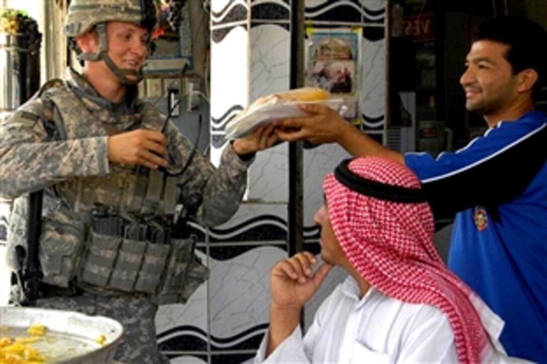 U.S. Army Staff Sgt. Jon Anderstrom buys baklava, a pastry with honey and nuts, from a local shop while he meets with Iraqi shop owners at Cedar Market, Mosul, Iraq, Sept. 21, 2008. Anderstrom is assigned to Company C, 1st Battalion, 8th Infantry Regiment. 
