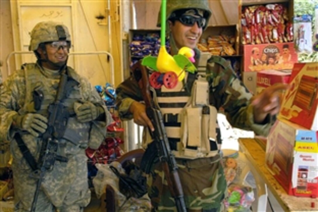 U.S. Army Sgt. Deguzman, left, window shops for toys at a local market stand with an Iraqi soldier during their dismounted patrol in Ad Diwaniyah, Iraq, Sept. 30, 2008. Deguzman is assigned to the 4th Infantry Division's Company C, 2nd Battalion, 8th Infantry.