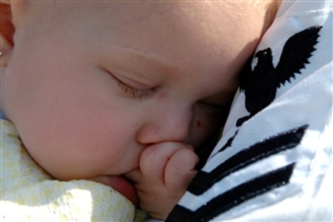 A baby falls asleep in her father's arms during the homecoming ceremonies for the guided-missile frigate USS McInerney, which returned to Naval Station Mayport, Fla., after a six-month deployment, Oct. 5, 2008.  