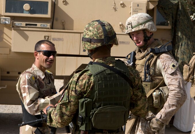 Iraqi army officers speak with Capt. Michael Mayne, a 35-year-old Napa, Calif. native and commanding officer of Bravo Company, Task Force 1st Battalion, 3rd Marine Regiment, Regimental Combat Team 1, in Karmah, Iraq, Oct. 7. Marines of Company B were conducting a mission to collect retinal and photographic identification of local Iraqi adult male residents in collaboration with the Iraqi Army in their area of operation. Effectively identifying Iraqis in Karmah is pivotal to limit insurgency movement by eliminating their concealment, and pursuing any remaining threats in the "Western gate to Anbar." (U.S. Marine Corps photo by Lance Cpl. Geoffrey T. Campbell/Released)