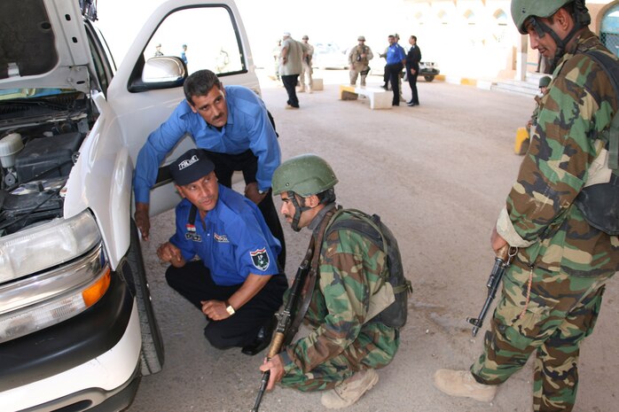 Iraqi border police officers and Iraqi commandos search a civilian vehicle passing through the Iraqi border from Jordan during an evaluation exercise Oct. 7 at the Port of Trebil, the only major thoroughfare between the two countries.::r::::n::The exercise concluded a week-long border police training course which Marines and U.S. Customs and Border Patrol officials conducted for 26 members of the Iraqi Security Forces. ::r::::n::