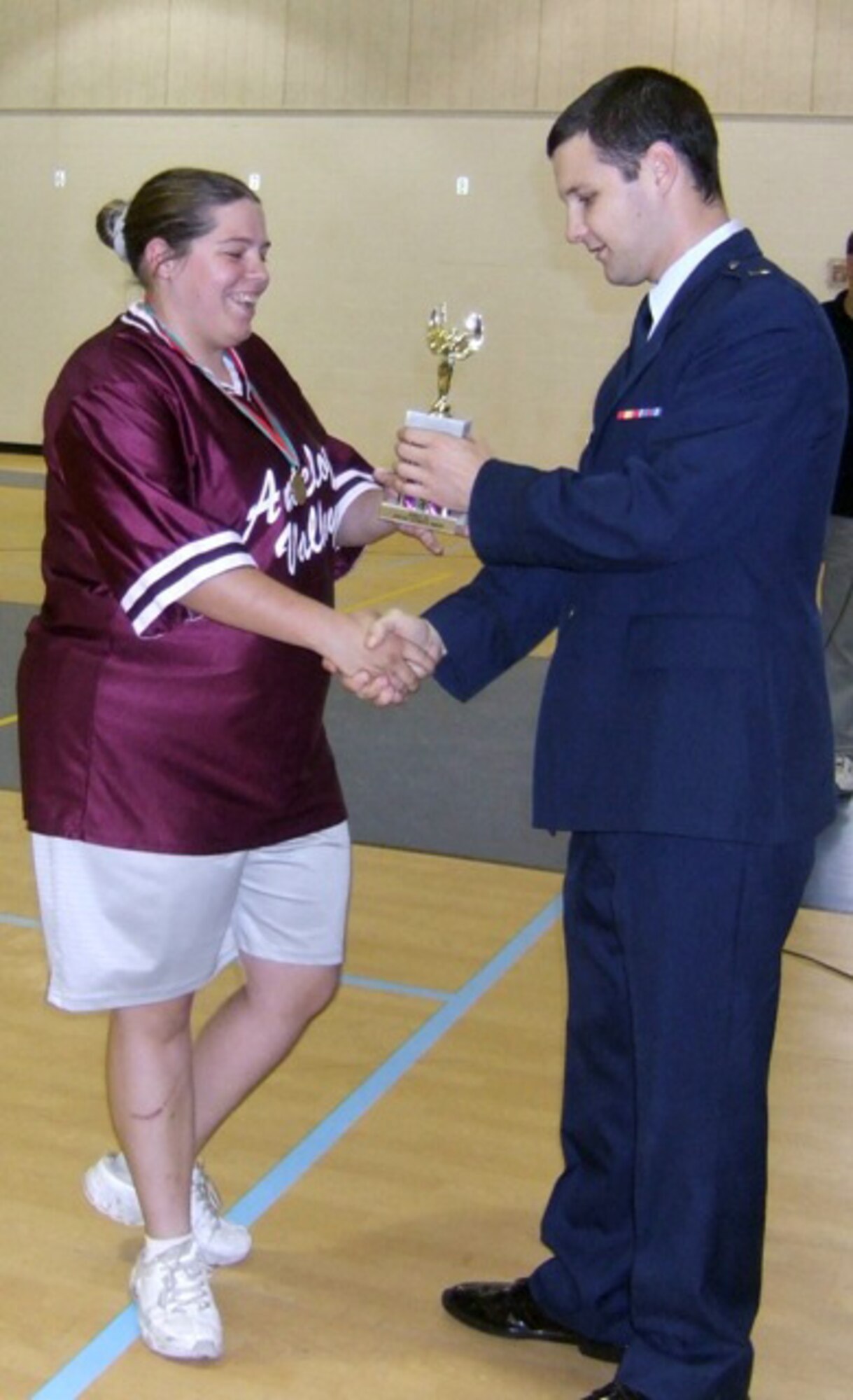 First Lt. David Hillshafer (right), 419th Flight Test Squadron operations engineer, hands out the Spirit of Special Olympics Sportsmanship award to Dawn Poulsom during a Special Olympics at Quartz Hill, Calif., Oct. 4. Lieutenant Hillshafer was the master of ceremonies during the event. The Edwards Blue Eagles Honor Guard also provided support during the Special Olympics. (Courtesy photo)