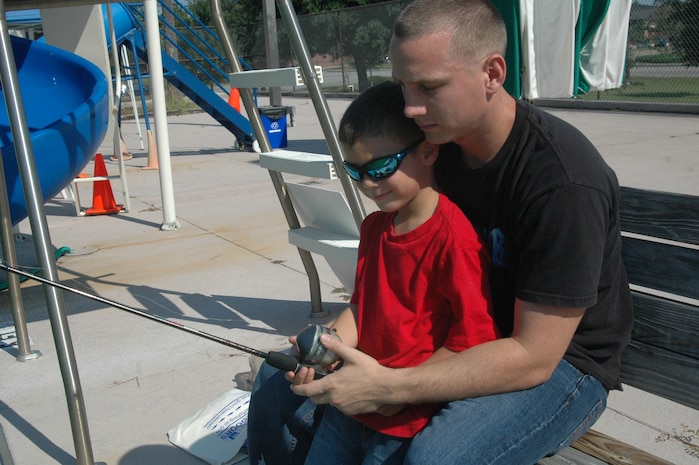 Senior Airman Brian Parker fishes for striped bass with his son, Dionta, 5, at the Charleston AFB Fishing Derby Oct. 4 at the bases pool. The Charleston AFB Fishing Derby was an opportunity for base members to fish and have a fish fry lunch. Airman Parker is assigned to the 437th Aircraft Maintenance Squadron. (U.S. Air Force photo/Staff Sgt. Sam Hymas)
