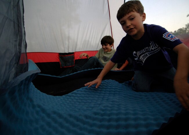 Nicolas Petrick, right and Hunter Petrick, left, lay padding in their tent in preparation for the the 437th Force Support Squadron Camp Little Links at the Wrenwoods Golf Course on Charleston AFB Oct. 3. Military families set up tents, cooked out and participated in a night time putting challenge. (U.S. Air Force photo/Airman 1st Class Timothy Taylor) 
