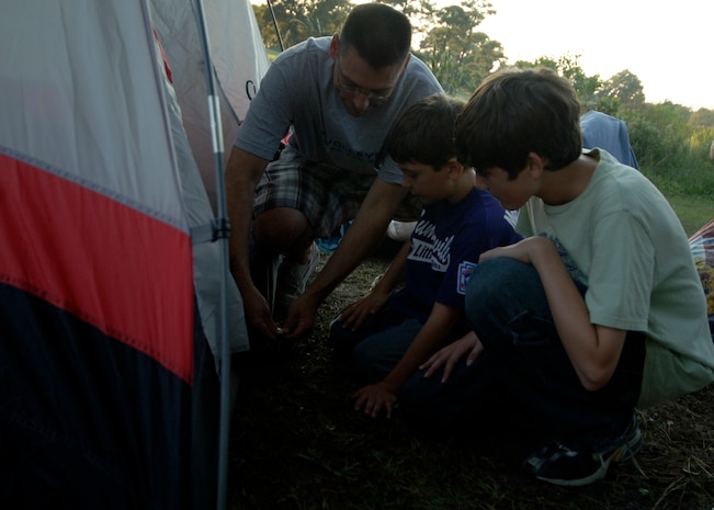 Lt. Col. James Petrick and his sons, Nicolas and Hunter, assemble a tent at the Wrenwoods Golf Course in preparation for a night under the stars on Charleston AFB Oct. 3. More than 15 Team Charleston family members participated in the 437th Force Support Squadron Camp Little Links. Colonel Petrick is the 437th Logistics Readiness commander. (U.S. Air Force photo/Airman 1st Class Timothy Taylor) 
 