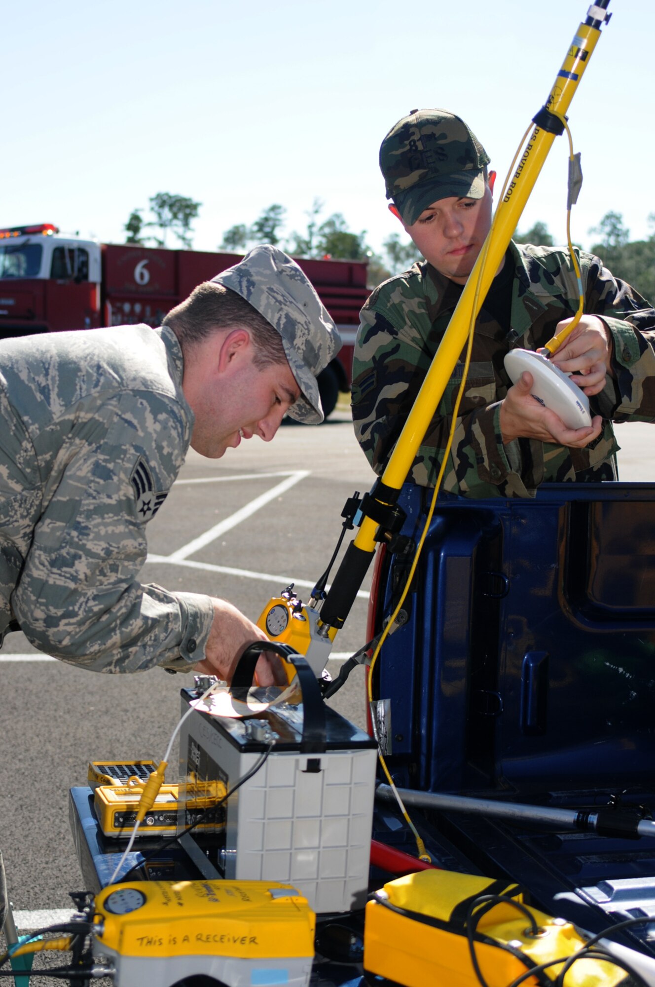 Senior Airman Michael Fagan, left, and Airman 1st Class Aaron Scott, 81st Civil Engineer Squadron, assemble a global positioning surveying system to plot the accident location.  (U.S. Air Force photo by Kemberly Groue)