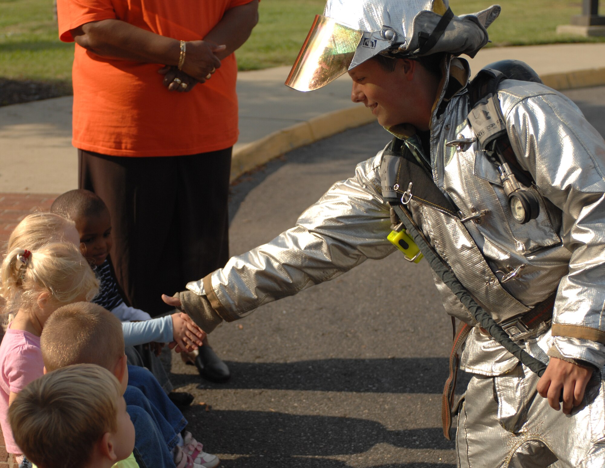 LANGLEY AIR FORCE BASE, Va. – Airman 1st Class Gaylord Range, 1st Civil Engineer Squadron firefighter, shakes hands with a child from the Russ Child Development Center Oct. 6.  The firefighters taught the children about fire prevention and what to do in an emergency situation.   (U.S. Air Force photo/Airman 1st Class Zachary Wolf)