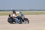 Ronald Dalton, 12th Flying Training Wing volunteer motorcycle safety instructor, demonstrates how to take a curve during the monthly motorcycle safety course in September. About 130 students have been trained by Mr. Dalton in the course so far. (U.S. Air Force photo by Dave Terry)