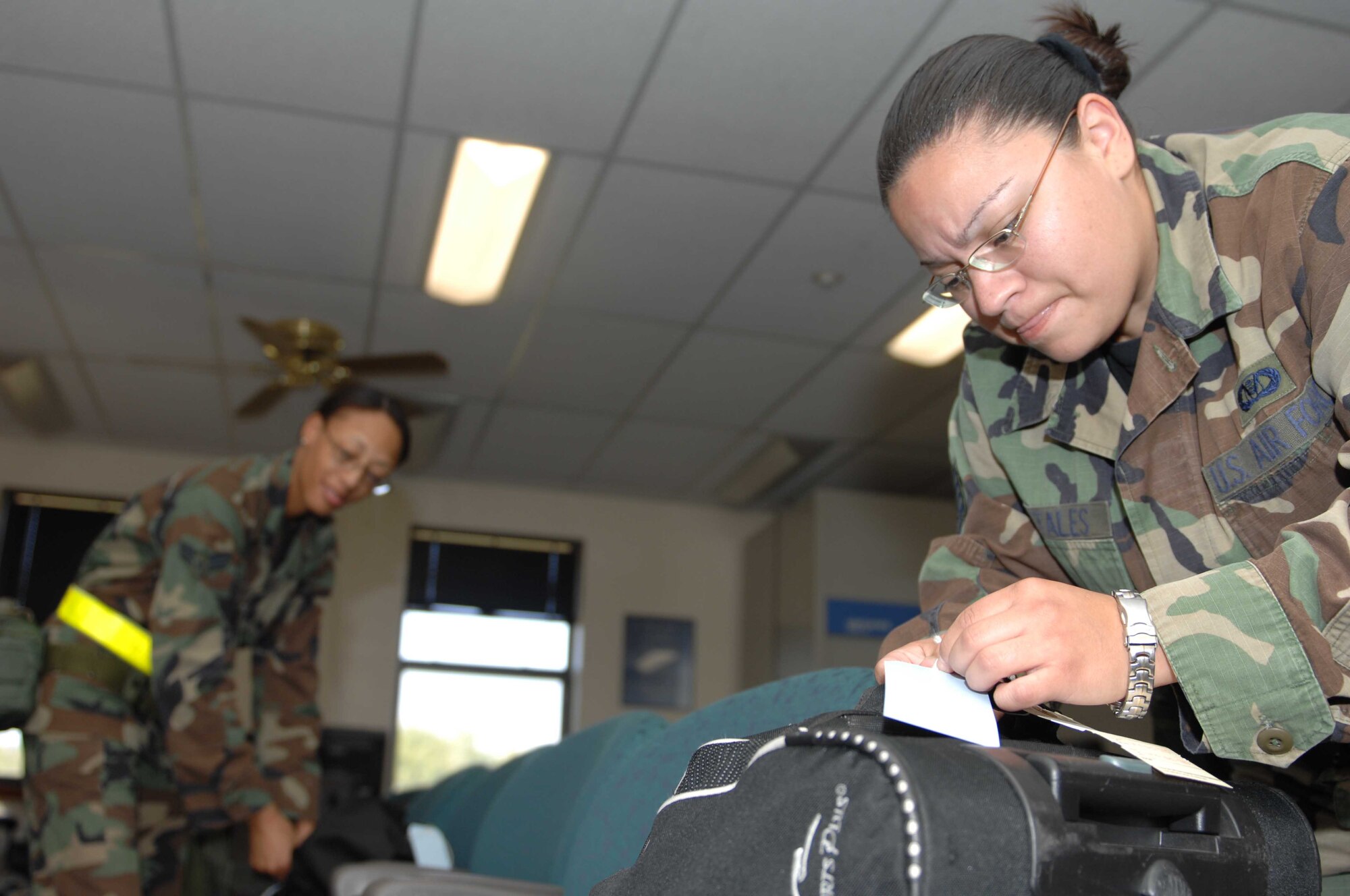 DYESS AIR FORCE BASE, Texas —  Staff Sgt. Katherine Portales places tags onto her luggage to meet requirements for the processing line as directed by her Unit Deployment Manager Oct. 5. (U.S. Air Force/photo Senior Airman Domonique Simmons)