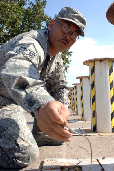 DYESS AIR FORCE BASE, Texas — Master Sgt. Robert Uyeno, 7th Bomb Wing information management, strings  a wire through and locks spring barriers in place during a force protection condition (FPCON) level change Oct. 4. The Phase 1 Operational Readiness Inspection lasted Oct. 2 to 8. (U.S. Air Force photo/ Senior Airman Domonique Simmons)