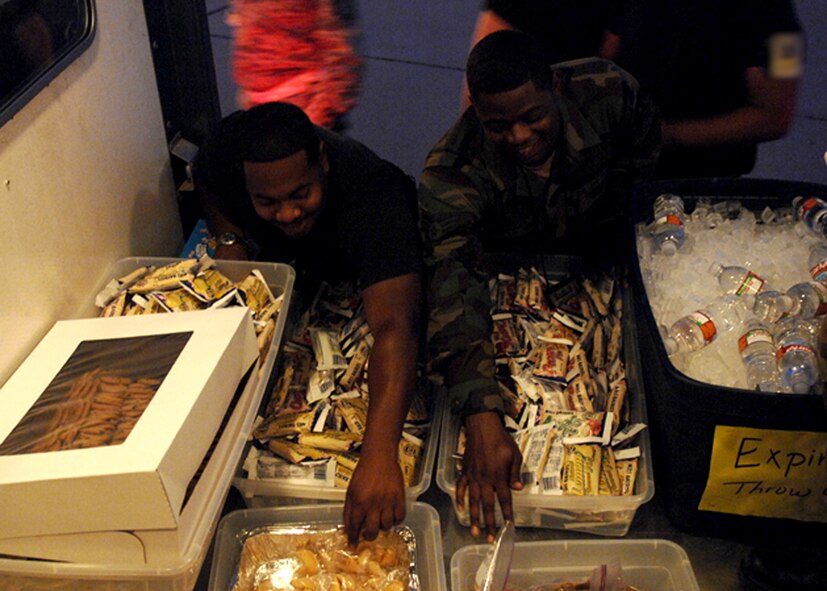 DYESS AIR FORCE BASE, Texas—Two Airman dive into a truck load of sweets and refreshments during the Operational Readiness Inspection here Oct. 3. First sergeants organized a “cookie bus” to drive all over base during the ORI Oct. 2 to 8, to raise morale and ensure Airman were energized and vigilant for the tasks at hand. (U.S. Air Force photo/Airman 1st Class Stephen Reyes)