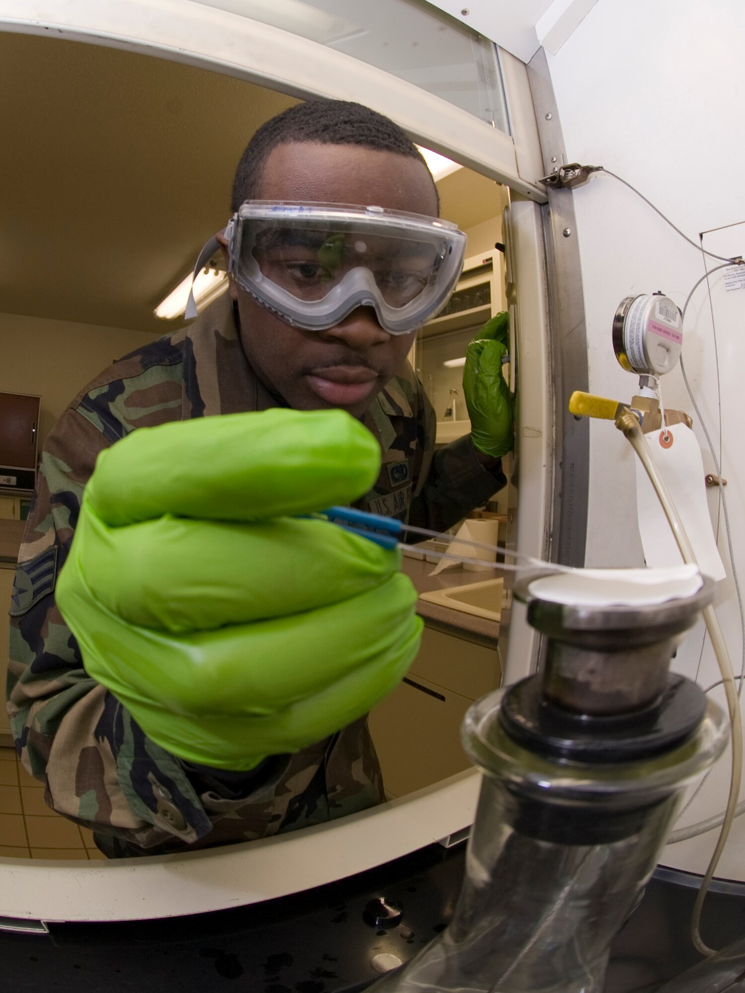 ELMENDORF AIR FORCE BASE, Alaska -- Senior Airman Vince Jacobs, 3rd Logistics Readiness Squadron, removes a test sample after performing a Stored Energy System (SES) purge. The purge allows Airman Jacobs and fellow fuel flight members to see if the SES is working properly on an F-22 Raptor. If the sample has more than 35 microns of contamination, it would ground the aircraft. (U.S. Air Force photo/Staff Sgt. Joshua Garcia)