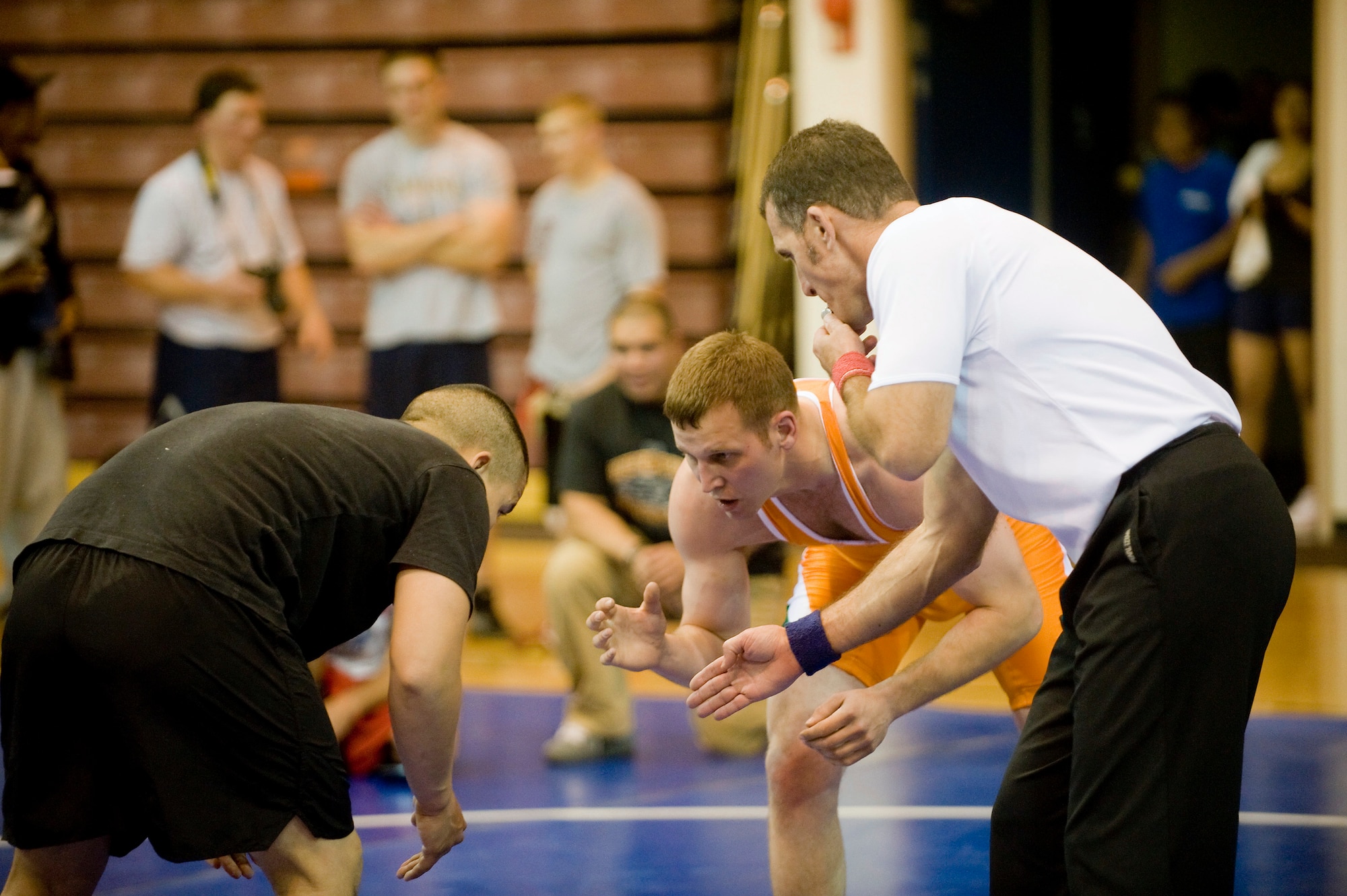 FORT RICHARDSON, Alaska -- Tech. Sgt. Travis Schlapbach (middle), 477th Aircraft Maintenance Squadron, faces off with Army Pfc. William Bonner (left) at Intramural Post Wrestling Meet Oct. 1. The wrestling meet included Airmen and Soldier competitors. (U.S. Air Force photo/Senior Airman Jonathan Steffen)