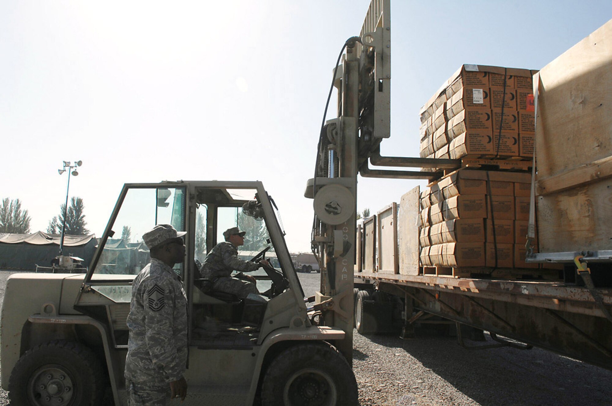 Chief Master Sgt. Stanley Walker, helps guide forklift driver, Tech. Sgt. Daryl Maniscalco, as he loads a pallet of food rations to a flatbed truck of humanitarian aid intended for survivors of an Oct. 5 earthquake in southern Kyrgyzstan. Airmen from Manas Air Base, Kyrgyzstan, sent thousands of pounds of aid, Oct. 8, that included pallets of food rations, bottled water, surplus military cold weather gear and more than 120 boxes containing 3,000 pounds of adult and children's winter clothing, blankets and toys. A call for personal donations resulted in more than 40 Airmen donating their own blankets they deployed here with. Chief Walker is assigned to the 376th Expeditionary Logistics Squadron. (U.S. Air Force photo/Tech. Sgt. Michael Voss)
