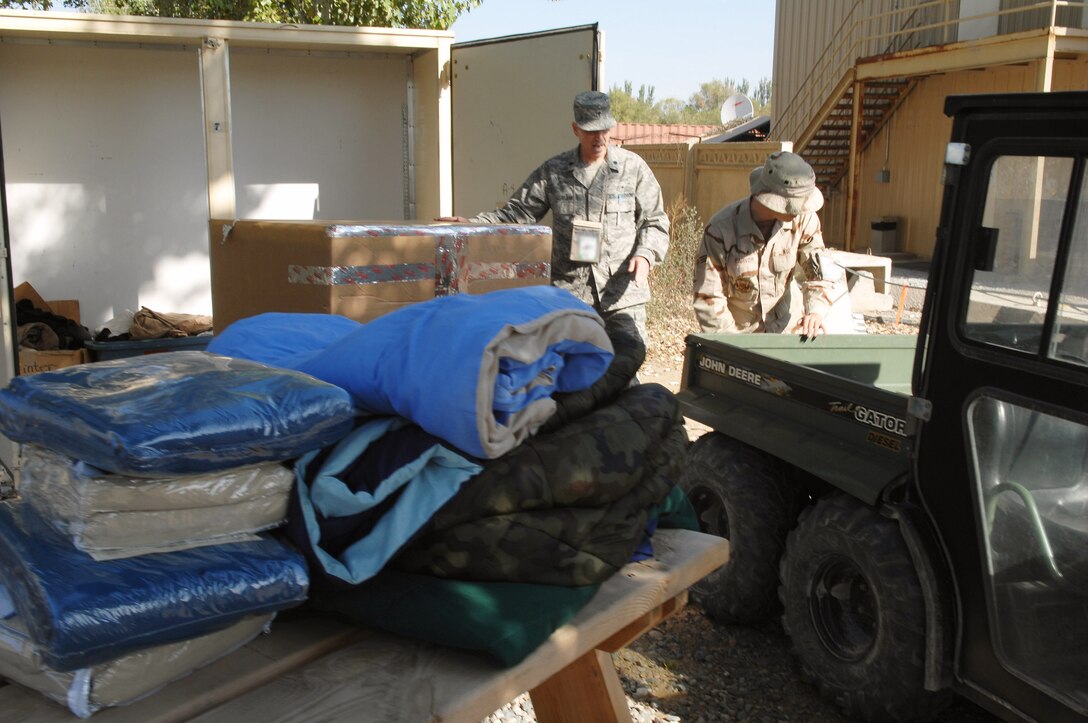 Lt. Col. Tim Bejian and Senior Airman Alex Farver help load boxes of blankets and clothes as a part of a humanitarian aid shipment intended for survivors of an Oct. 5 earthquake in southern Kyrgyzstan. Airmen from Manas Air Base, Kyrgyzstan, sent thousands of pounds of aid, Oct. 8, that included pallets of food rations, bottled water, surplus military cold weather gear and more than 120 boxes containing 3,000 pounds of adult and children's winter clothing, blankets and toys. A call for personal donations resulted in more than 40 Airmen donating their own blankets they deployed here with. Colonel Bejian is the 376th Air Expeditionary Wing chaplain. Airman Farver is assigned to the 376th AEW public affairs. (U.S. Air Force photo/Tech. Sgt. Michael Voss)