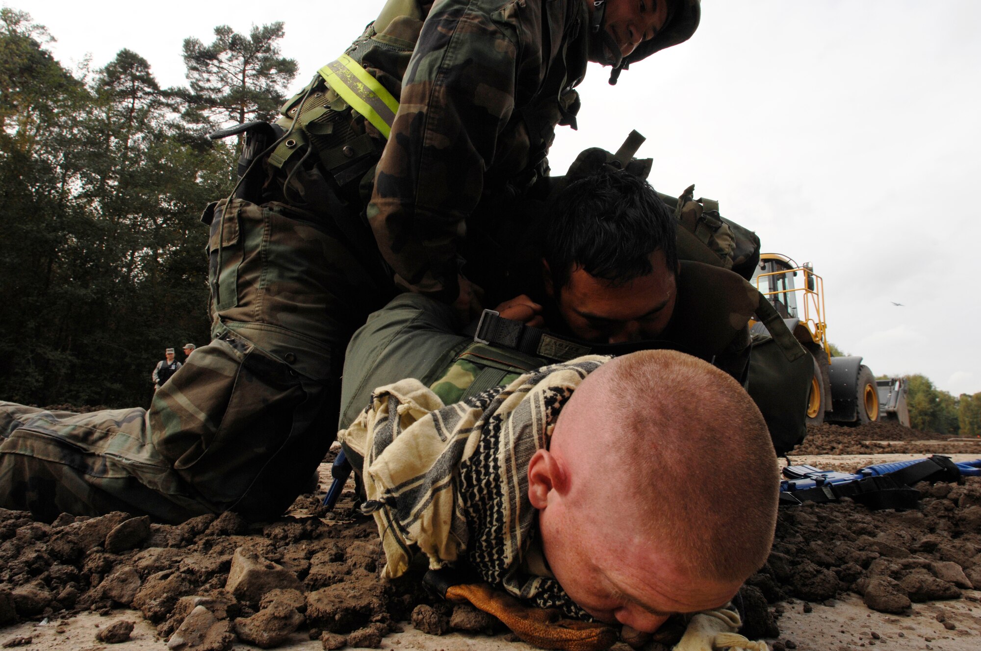 United States Air Force Staff Sgt. Ty Bun (left) and Airman 1st Class Justin Cather, 100th Civil Engineer Squadron, Royal Air Force Mildenhall, England, detain a member of cadre, Staff Sgt. Chris Harward, 86th Construction and Training Squadron civil engineer operations instructor, in support of the Silver Flag exercise 09-01, Ramstein Air Base, Germany, Oct. 7, 2008. Silver Flag provides expeditionary combat support training to Airmen in the civil engineer, personnel services, contracting and services career fields, preparing them for upcoming deployments. (U.S. Air Force photo by Senior Airman Amber Bressler)(Released)*