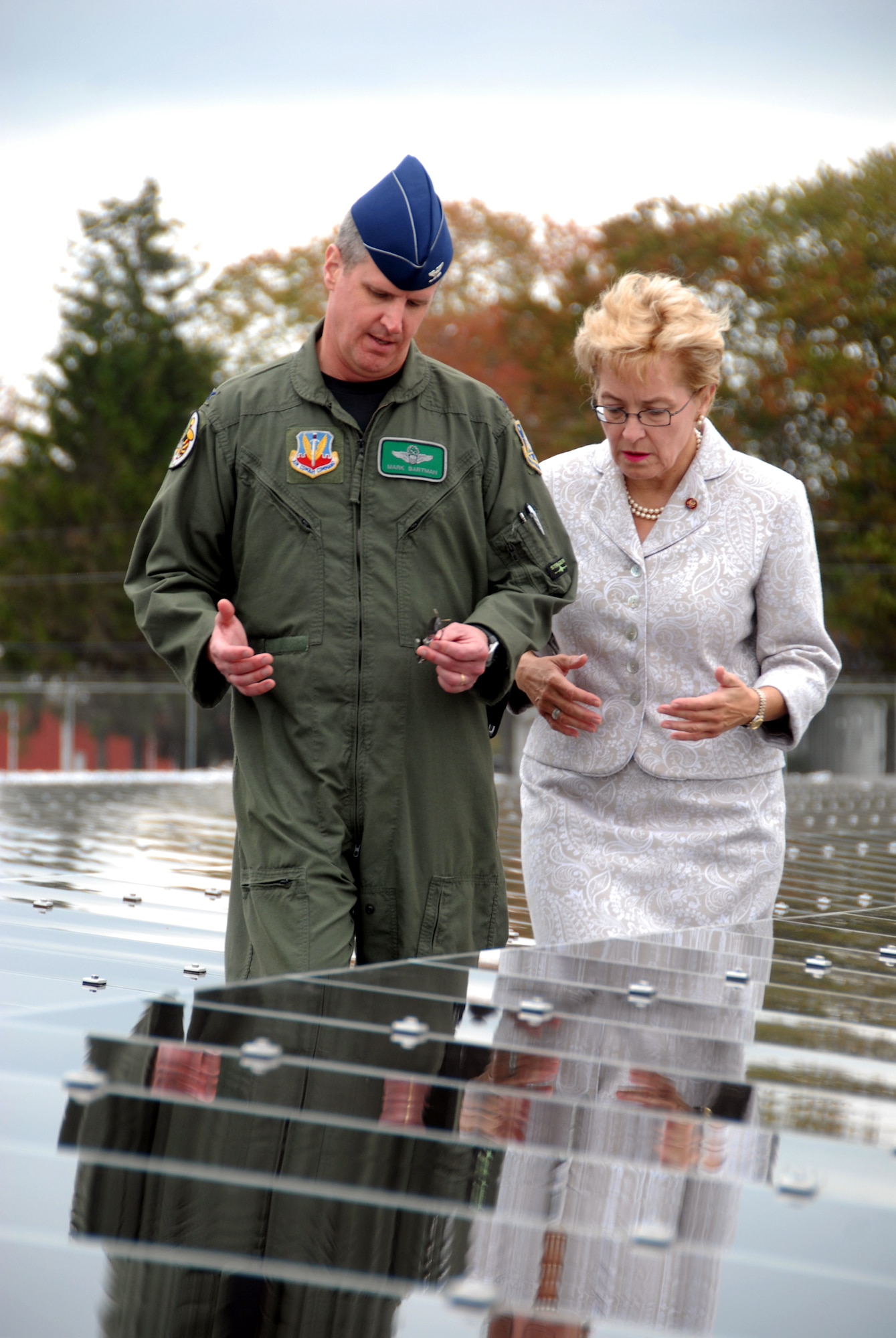 Col. Mark E. Bartman, 180th Fighter Wing Commander, Ohio Air national Guard and Congresswoman Marcy Kaptur walk among the rows of solar panels at the 180th Fighter Wing's Alternative Energy site on September 27, 2008. The solar field is part of the 180th FW's Renewable Energy Project, funded by the Department of Defense Research and Development Program in an effort to reduce the 180th's use of limited fossil fuel and dependence on foreign energy sources. Once completed, the solar field is expected to produce 800-900 Kilowatts of electricity, which will allow the 180th to save approximately 37.5% on the annual electricity budget. The solar field will also reduce the amount of coal burned to produce energy by almost 250 tons annually, while at the same time reducing harmful emissions and greenhouse gasses. USAF Photo by Senior Airman Jodi Joice (Released).
