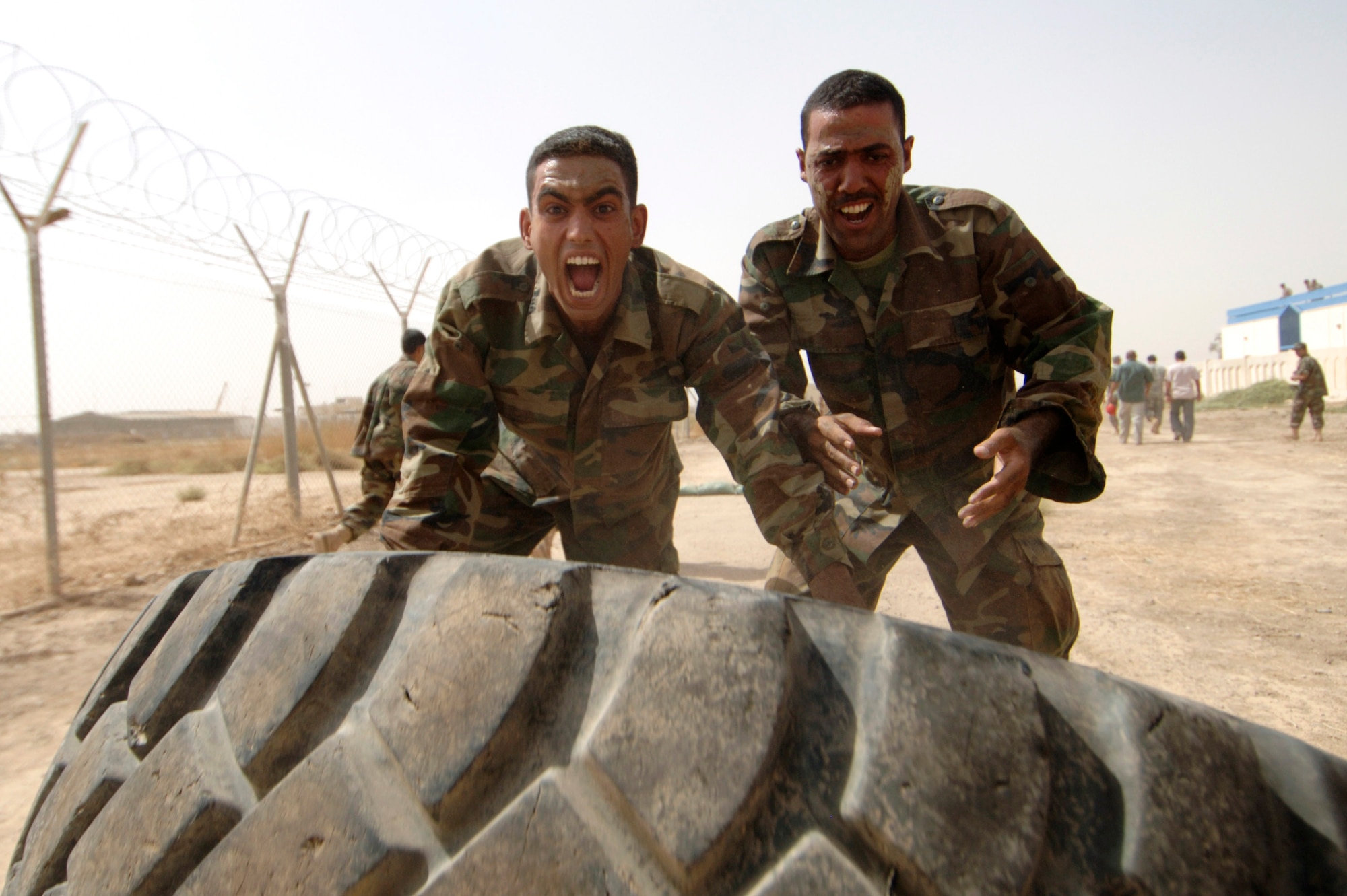 Iraqi warrant officers flip a tire during their run of the Iraqi air force basic military training tactical course at Al Taji Air Base, Iraq, Sept. 27. The tactical course tests their ability to work as a team and negotiate a variety of obstacles. (U.S. Air Force photo/Staff Sgt. Paul Villanueva II) 