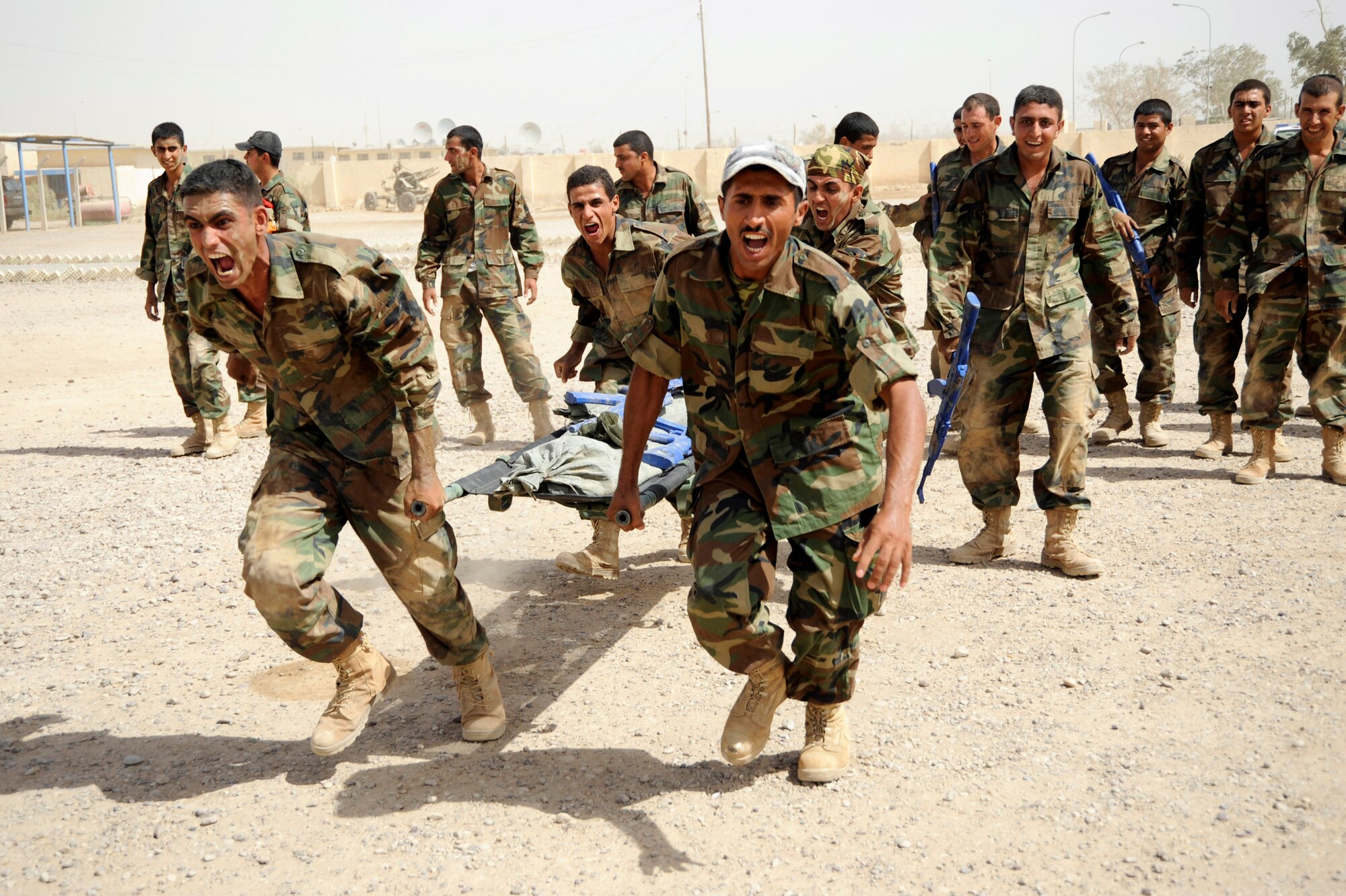 Iraqi air force warrant officers carry a litter weighted down with blue training rifles and sand bags during their run of the tactical course at Al Taji Air Base, Iraq, Sept. 27. The tactical course tests their ability to work as a team and negotiate a variety of obstacles. (U.S. Air Force photo/Staff Sgt. Paul Villanueva II) 
