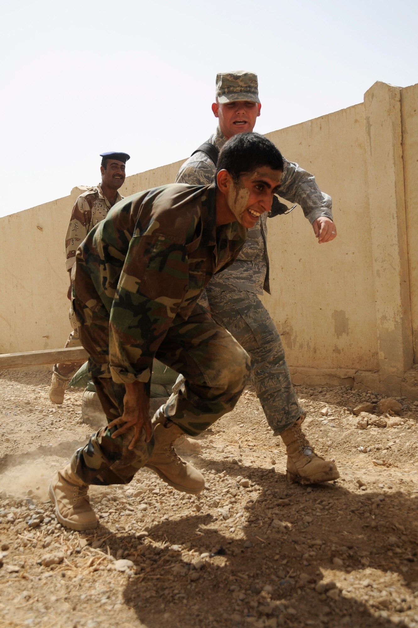 Staff Sgt. Matthew Coltrin motivates an Iraqi warrant officer as he runs the basic military training tactical course. Sergeant Coltrin and Tech. Sgt. Chris Ramsdell created the course with materials they found around at Al Taji Air Base, Iraq, Sept. 27. Sergeant Coltrin a military training instructor with the 370th Expeditionary Training Squadron.(U.S. Air Force photo/Staff Sgt. Paul Villanueva II)