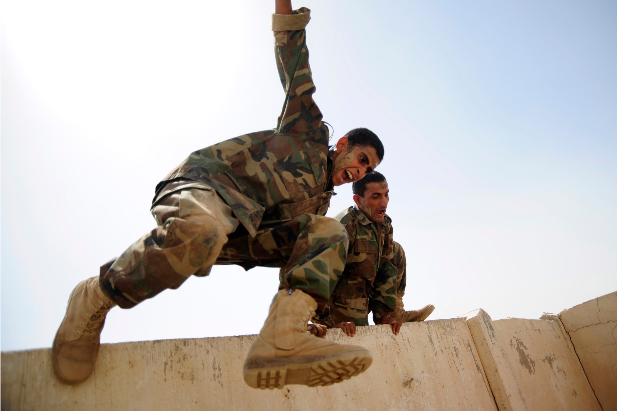 Iraqi air force warrant officers jumps over the high wall portion of the basic military training tactical course at Al Taji Air Base, Iraq, Sept. 27. (U.S. Air Force photo/Staff Sgt. Paul Villanueva II)