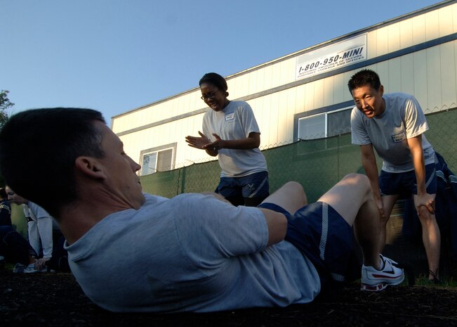 Todd Cyr completes the sit-up portion while his partner, Kenny Maeng, counts his completed repetitions during the Commander's Fitness Challenge at the Charleston AFB Fitness Center Oct.3. The Commander's Fitness Challenge is held monthly to promote fitness and esprit de corps. Cyr and Maeng are with the 437th Aerial Port Squadron. (U.S. Air Force photo/Airman 1st Class Timothy Taylor)