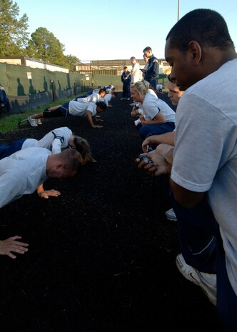 Participants watch and count the push-ups their partners complete during the Commander's Fitness Challenge behind the Charleston AFB fitness center Oct. 3. The Commander's Fitness Challenge is held monthly to promote fitness and esprit de corps. (U.S. Air Force photo/Airman 1st Class Timothy Taylor) 
