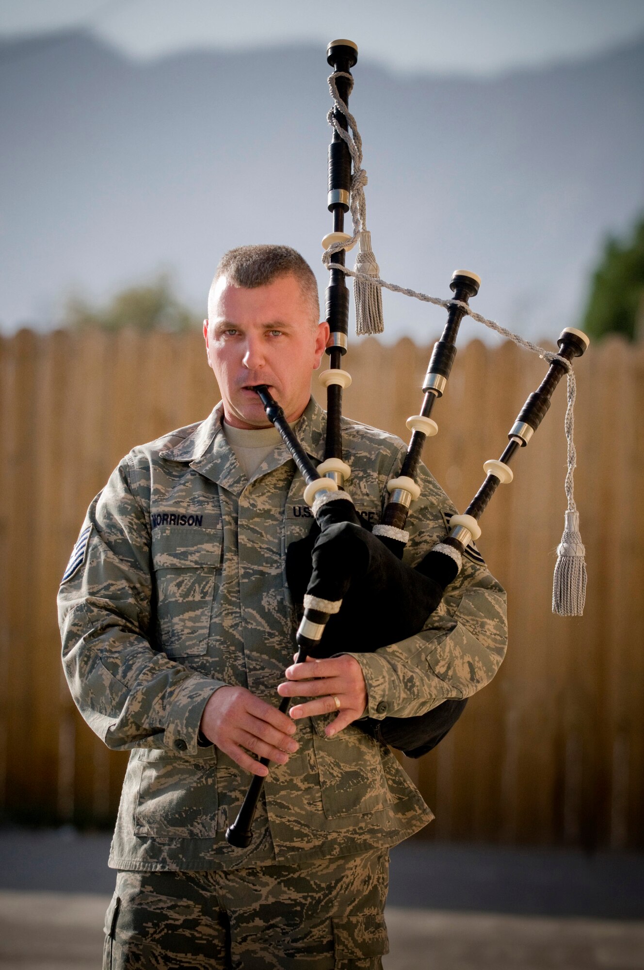 Tech Sgt. Iain Morrison, deployed to the 455th Expeditionary Civil Engineer Squadron from Patrick Air Force Base, Fla., plays the bagpipes outside of the Enduring Faith Chapel following a church service at Bagram Air Field, Afghanistan, Oct. 5. Sergeant Morrison has volunteered to play his bagpipes for approximately 40 fallen comrade ceremonies during his deployment here. (U.S. Air Force photo illustration by Staff Sgt. Samuel Morse)