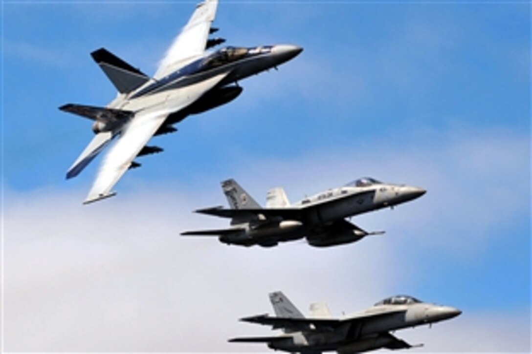 U.S. Navy Capt. John Aquilino, outgoing commander of Carrier Air Wing 2, banks an F/A-18E Super Hornet strike fighter over the aircraft carrier USS Abraham Lincoln, turning the lead of the formation over to incoming commander Capt. Alton Ross, during CVW 2 aerial change of command ceremony over the Pacific Ocean, Oct. 6, 2008. The USS Lincoln and CVW 2 are returning from a seven-month deployment to the U.S. 5th Fleet area of operations. 