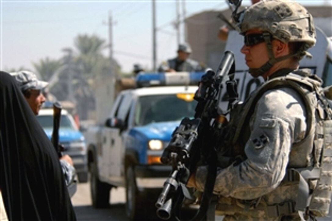 U.S. Army Sgt. Kris Shiplett and members of his unit provide security for Iraqi national police
handing out leaflets in Hada Mechanics, Baghdad, Iraq, Oct. 3, 2008. The soldiers are assigned to the 4th Infantry Division's Troop B, 7th Squadron, 10th Calvary Regiment.
