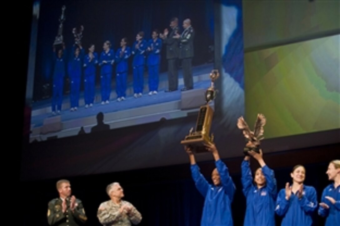 Chief of Staff of the Army Gen. George W. Casey Jr., and Sgt. Maj. of the Army Kenneth Preston present the Commander's Cup to the winning female team from Fort Bragg, N.C., for their performance in the Army Ten-Miler at the Association of the United States Army  annual meeting in Washington D.C., Oct 6, 2008. 