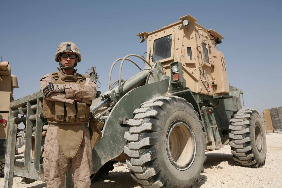 Sgt. Samuel R. Lott, a 23-year-old motor transportation operator from Mojave Valley, Ariz., with Headquarters and Support Company, Regimental Combat Team 1, stands in front of a heavy equipment tram at the motor transportation lot, Oct. 8, at Camp Ramadi Iraq. Lott is licensed to drive almost a dozen of the Marine Corps tactical vehicles, making him one of the most valuable assets during the move to Camp Ramadi.