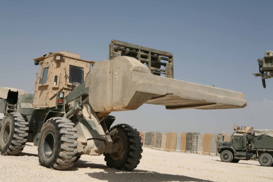 Sgt. Samuel R. Lott, a 23-year-old motor transportation operator from Mojave Valley, Ariz., with Headquarters and Support Company, Regimental Combat Team 1, moves concrete barriers throughout Camp Ramadi to assist RCT-1’s efforts in fortifying their new home Oct. 8. Lott is licensed to drive almost a dozen of the Marine Corps tactical vehicles, making him one of the most valuable assets during the move to Camp Ramadi.